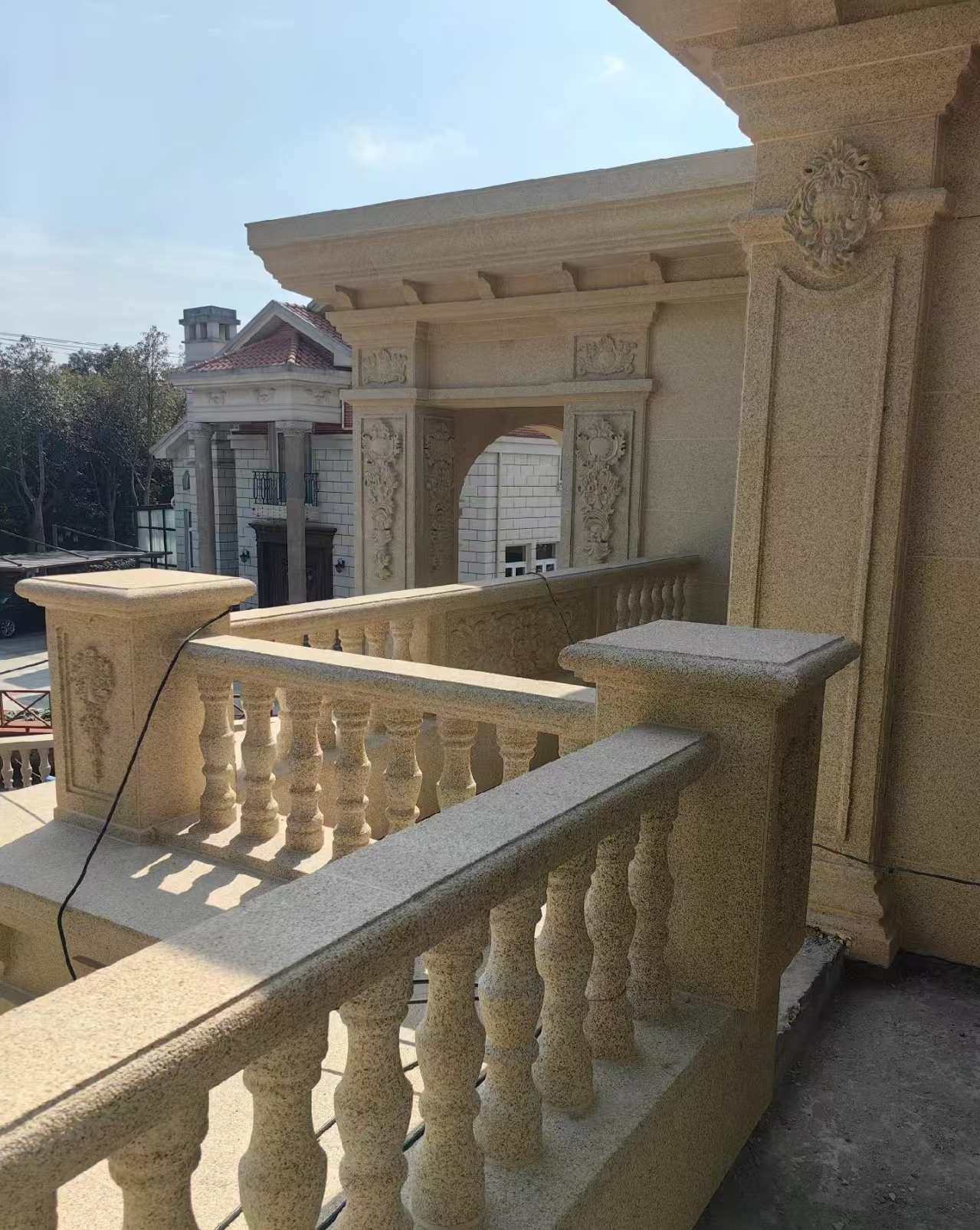 丽江 黄金麻别墅外墙干挂雕花配合阳台栏杆花瓶柱